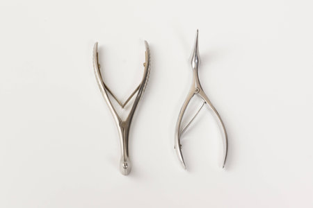 some chromeplated medical surgical tools lie on a white backgroundの写真素材