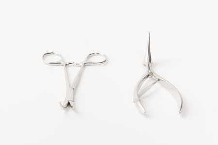 some chromeplated medical surgical tools lie on a white backgroundの写真素材