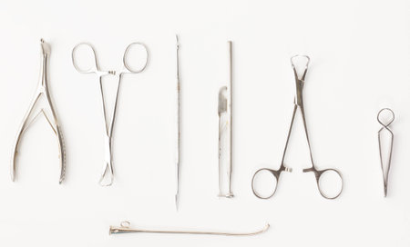 some chromeplated medical surgical tools lie on a white backgroundの写真素材