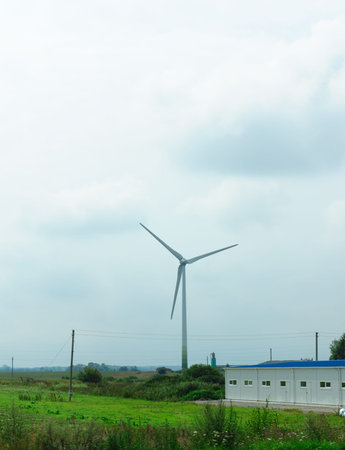 the wind-driven generator in the middle of a field serves for development of the cheap and ecology...