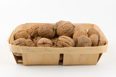 the wooden container is filled with a walnut on a white backgroundの写真素材
