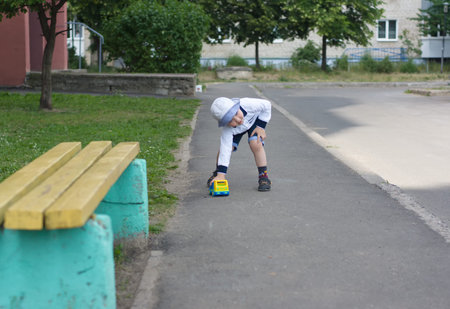 the little boy plays with the plastic machine on the streetの写真素材
