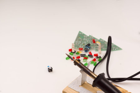 set of radio-electronic details of different color and soldering iron on a white background
