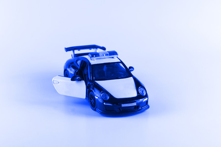 little toy car with opening doors on a white backgroundの写真素材