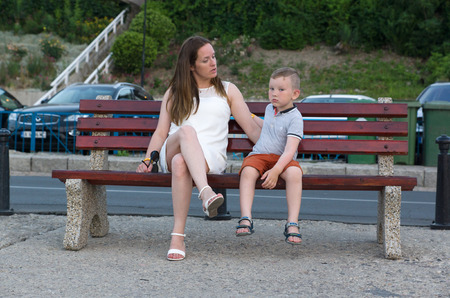 young woman talks with a child sitting on the benchのeditorial素材
