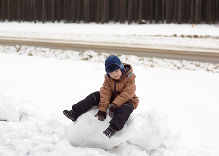 warmly dressed boy walking on a winter streetの写真素材