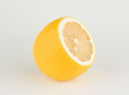large ripe lemon with a cut off tip on a white backgroundの写真素材