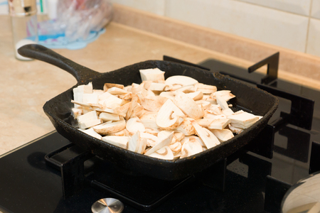 mushrooms are fried on a cast-iron frying panの写真素材
