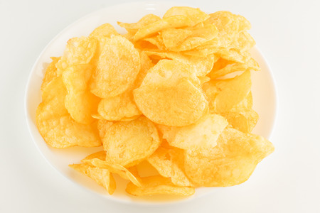 fresh potato chips isolated on a white plateの写真素材