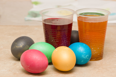 dyeing colored easter eggs in coloring solutionsの写真素材