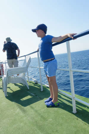 boy on a ship sets sail in the blue seaの写真素材
