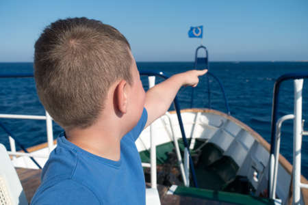 boy on a ship sets sail in the blue seaの写真素材
