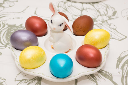Traditional Easter dinner or brunch with ham, colored eggs, hot cross buns, cake and vegetables. Easter meal dishes with holday decorations.の写真素材