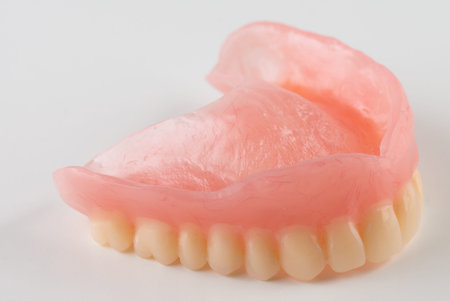 Removable plastic dentures for dental restoration on a white background