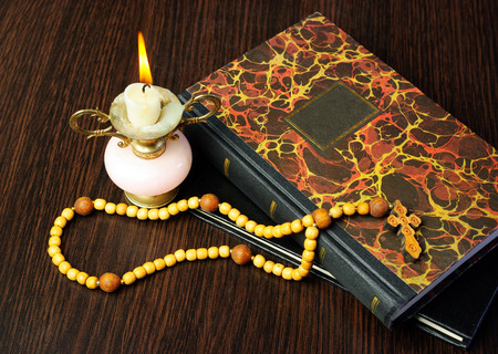 Christian cross on bible and burning candleの写真素材