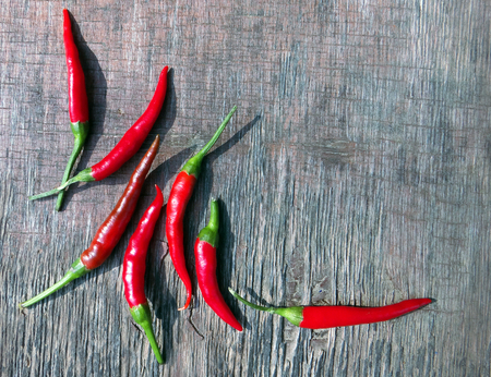 Fresh Red Hot Chili Peppers On The Rustic Wood Kitchen Table. Background With Copy Space.の写真素材