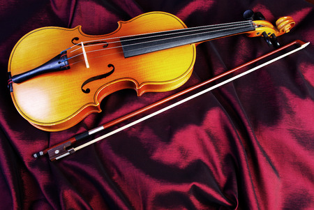 Violin on a color background. Violin on a purple silk background. Closeup.の写真素材