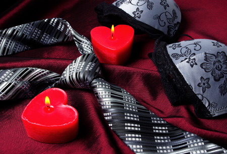 Close-up photo of gray men's tie and women's bra. Prelude of love. Romantic evening.の写真素材