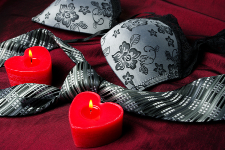 Close-up photo of gray men's tie and women's bra. Prelude of love. Romantic evening.の写真素材