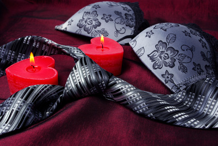 Close-up photo of gray men's tie and women's bra. Prelude of love. Romantic evening.の写真素材