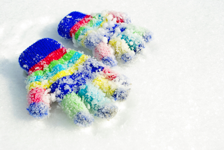 colorful gloves for children in the snowの写真素材