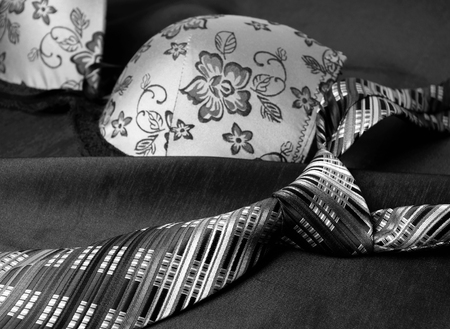 Close-up photo of gray men's tie and women's bra. Prelude of love. Romantic evening.の写真素材