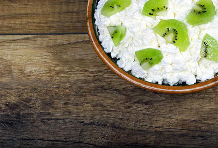 Homemade cottage cheese in a bowl on old wooden table.の写真素材