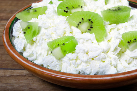 Homemade cottage cheese in a bowl on old wooden table.の写真素材