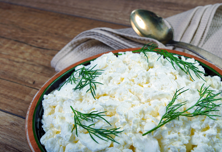 Homemade cottage cheese in a bowl on old wooden table.の写真素材