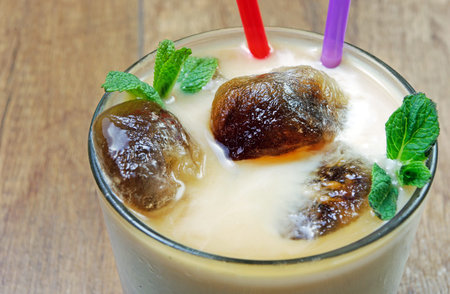 Milk with coffee ice cubes. Cold summer drink.