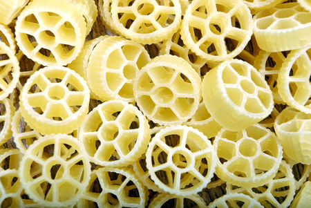 wheel shape pasta texture background. uncooked dry pastaの写真素材