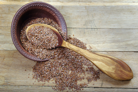 Raw seeds of flax in a wooden tableの写真素材