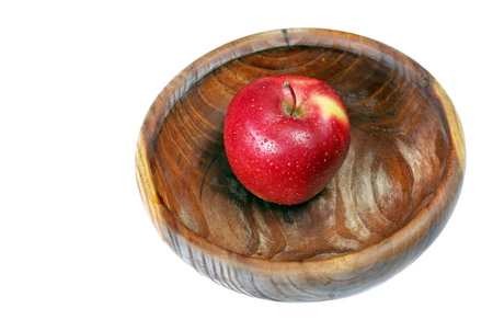 red apple on a wooden dish isolated on whiteの写真素材