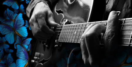 playing music blues. guitarist hands and guitar close up. playing electric guitar. blue morpho butterflies.の写真素材