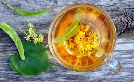 Cup of linden tea on the wooden table. Top view. herbal tea. Flu and cold remedies.の写真素材