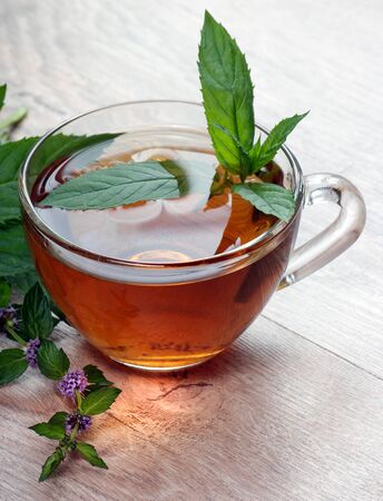 cup of mint tea on a wooden table. herbal tea. close upの写真素材