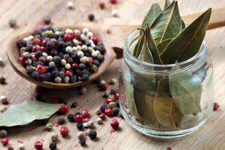 dry bay leaf on a wooden table. bay leaf and pepper mixture in a wooden spoonの写真素材