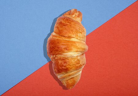 croissant top view. croissant on bright colorful background. fresh ruddy croissant on color cardboard.の写真素材