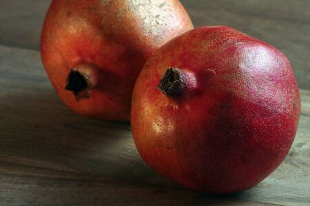 ripe red pomegranates on a wooden table. pomegranate fruits close upの写真素材