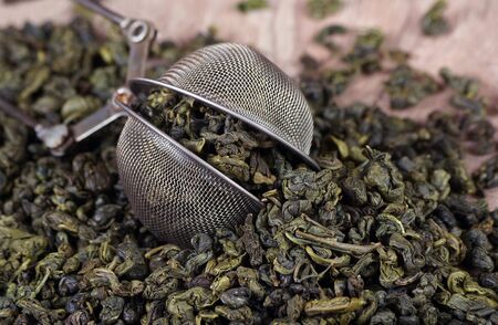green tea leaves in a tea strainer on a table. close upの写真素材
