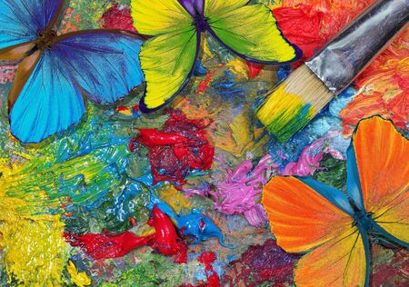 color concept. bright tropical morpho butterflies on an artist's palette. art paints and butterflies colorful backgroundの写真素材