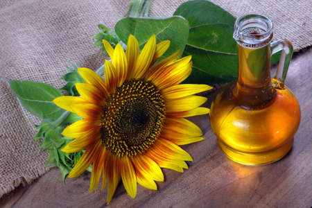 sunflower oil and a sunflower flower on the table. natural vegetable oil.の写真素材