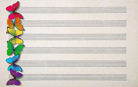 colors of rainbow. colorful multicolored morpho butterflies on music sheet. old music sheet texture backgroundの写真素材