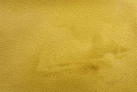 a sheet of watercolor paper painted with gold paint texture backgroundの写真素材