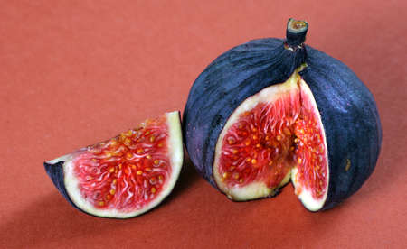 ripe fig fruit close-up on a red background.の写真素材