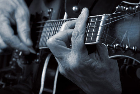 Guitarist hands and guitar close up. playing electric guitar black and white
