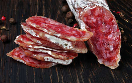 dried sausage on a wooden table. sausage fuet close-upの写真素材