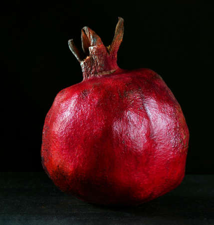 bright colorful ripe pomegranate on blackの写真素材