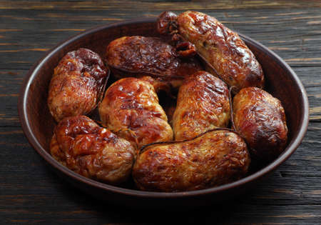 fried sausage in a bowl on a wooden table. top view.copy spaceの写真素材