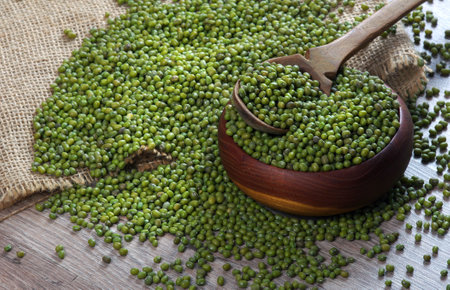 Mung beans in a wooden scoop on a table. close upの写真素材